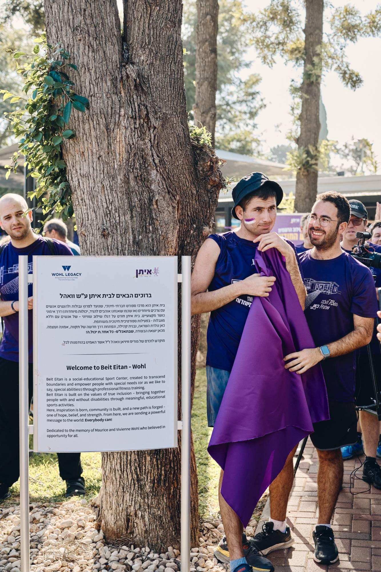 מתאמנים של איתן ליד שלט הכניסה לבית איתן